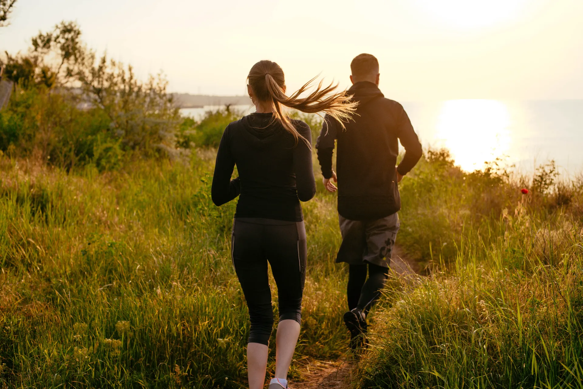young fit couple running on beach during sunrise o utc